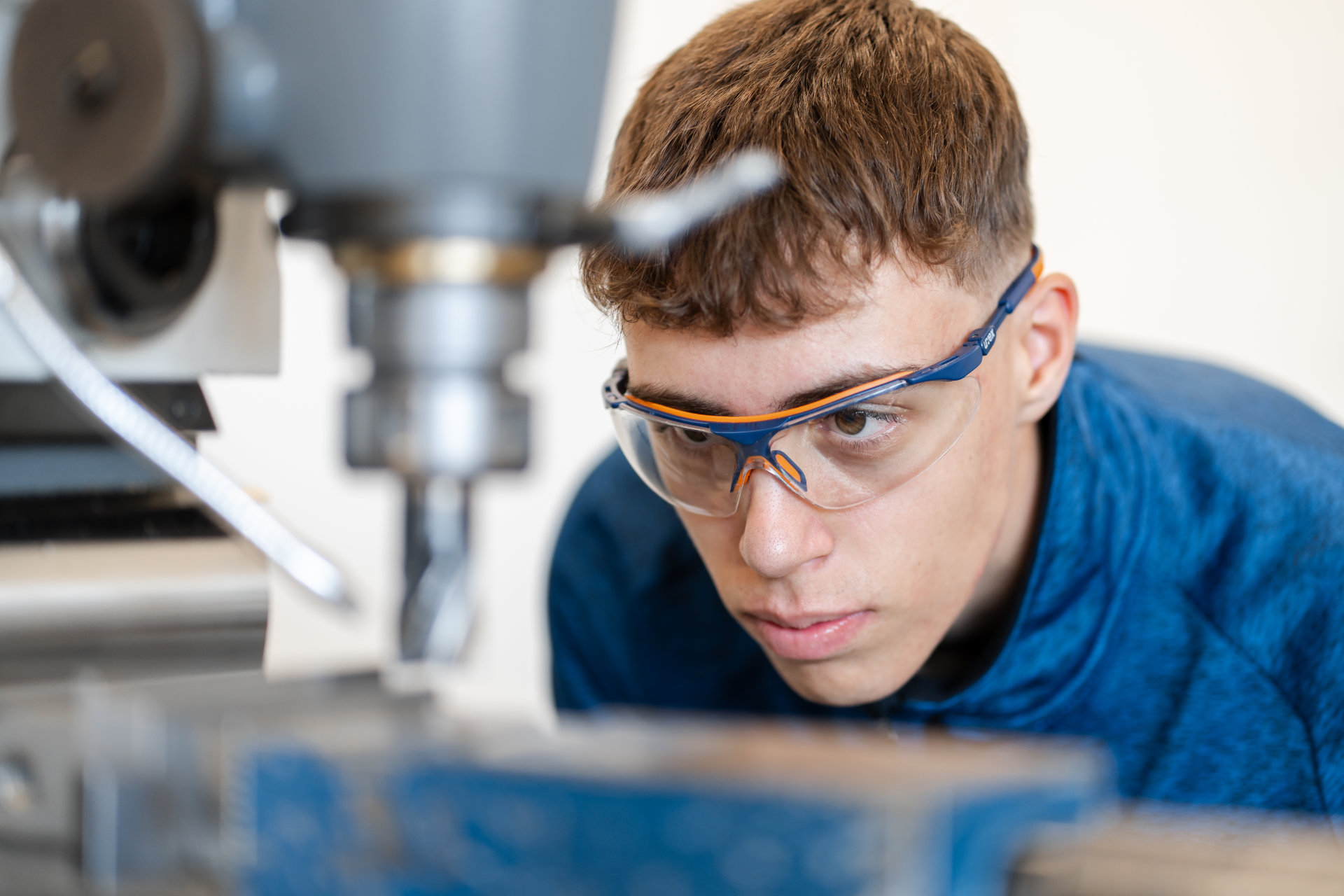 Focused technician closely monitoring a precision machine at work.
