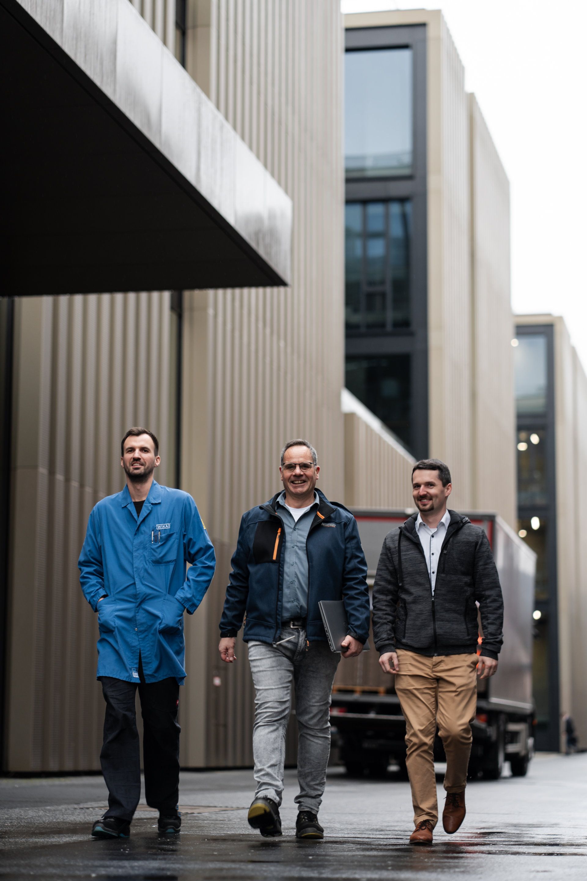 Three men confidently walking in an urban environment, each dressed in distinct styles – from casual to professional – showcasing diversity in jobs.