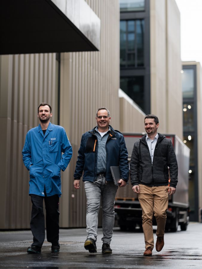 Three men confidently walking in an urban environment, each dressed in distinct styles – from casual to professional – showcasing diversity in jobs.